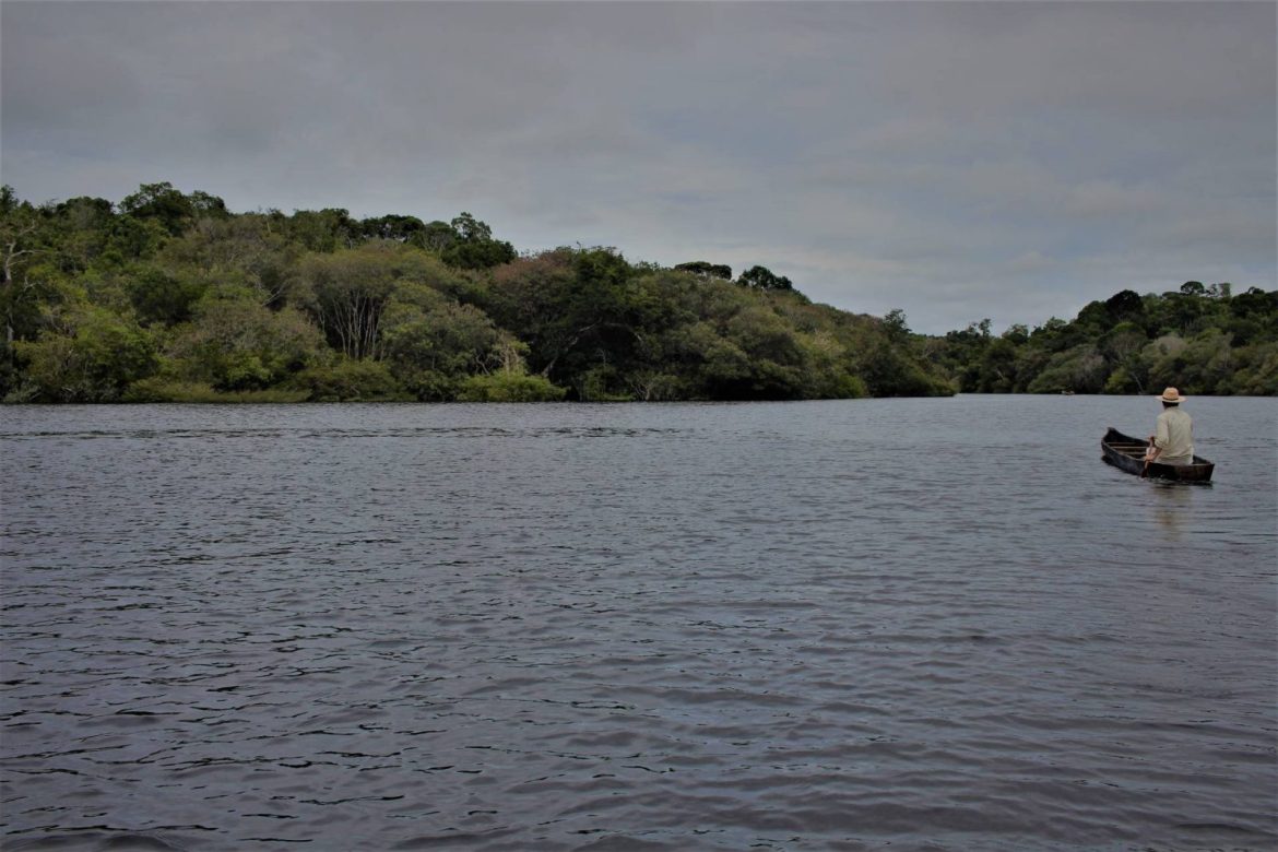 Canoeiro navegando pelo rio negro.