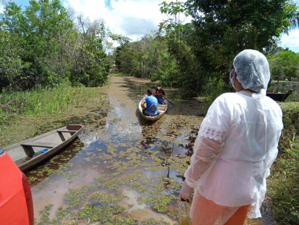 Homens remando em lago em busca de atendimento de saúde.