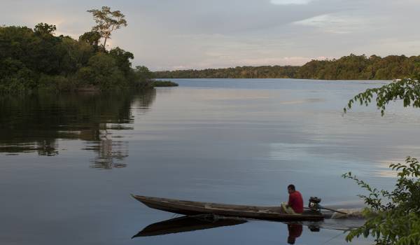 Ribeirinho navegando em sua canoa pelo rio.