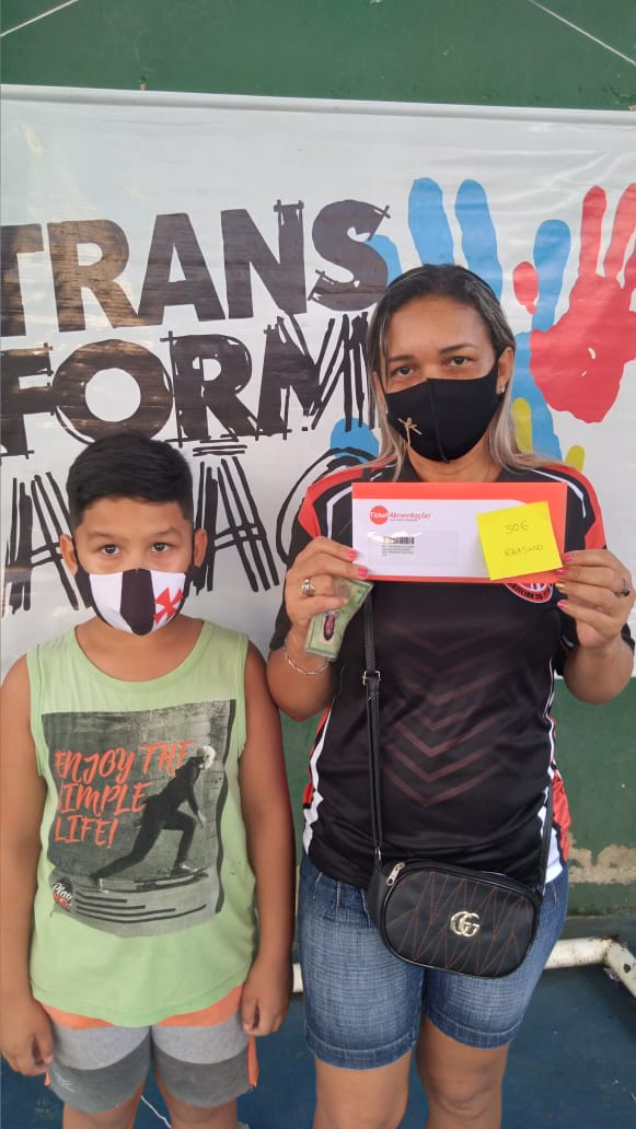 Família recebendo cartão alimentação através de uma iniciativa entre a Fundação Amazônia Sustentável (FAS) e a Organização Não Governamental (ONG) “Gerando Falcões”.