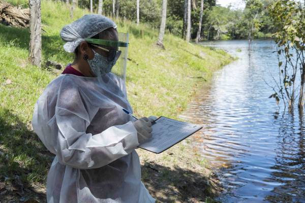 Profissional da saúde fazendo ficha para atendimento.