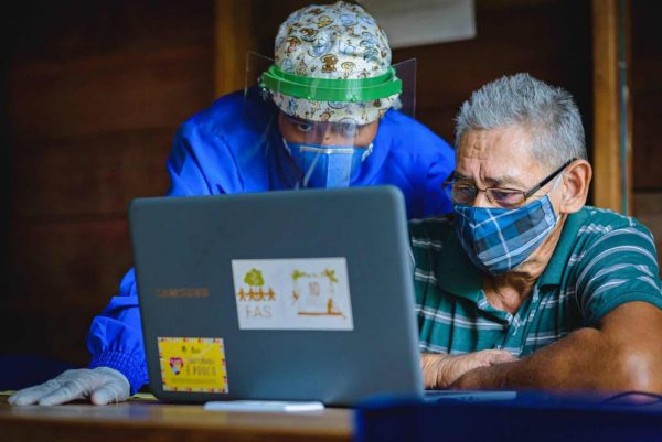 Homem recebendo atendimento de telessaúde em sua comunidade no interior do Amazonas.