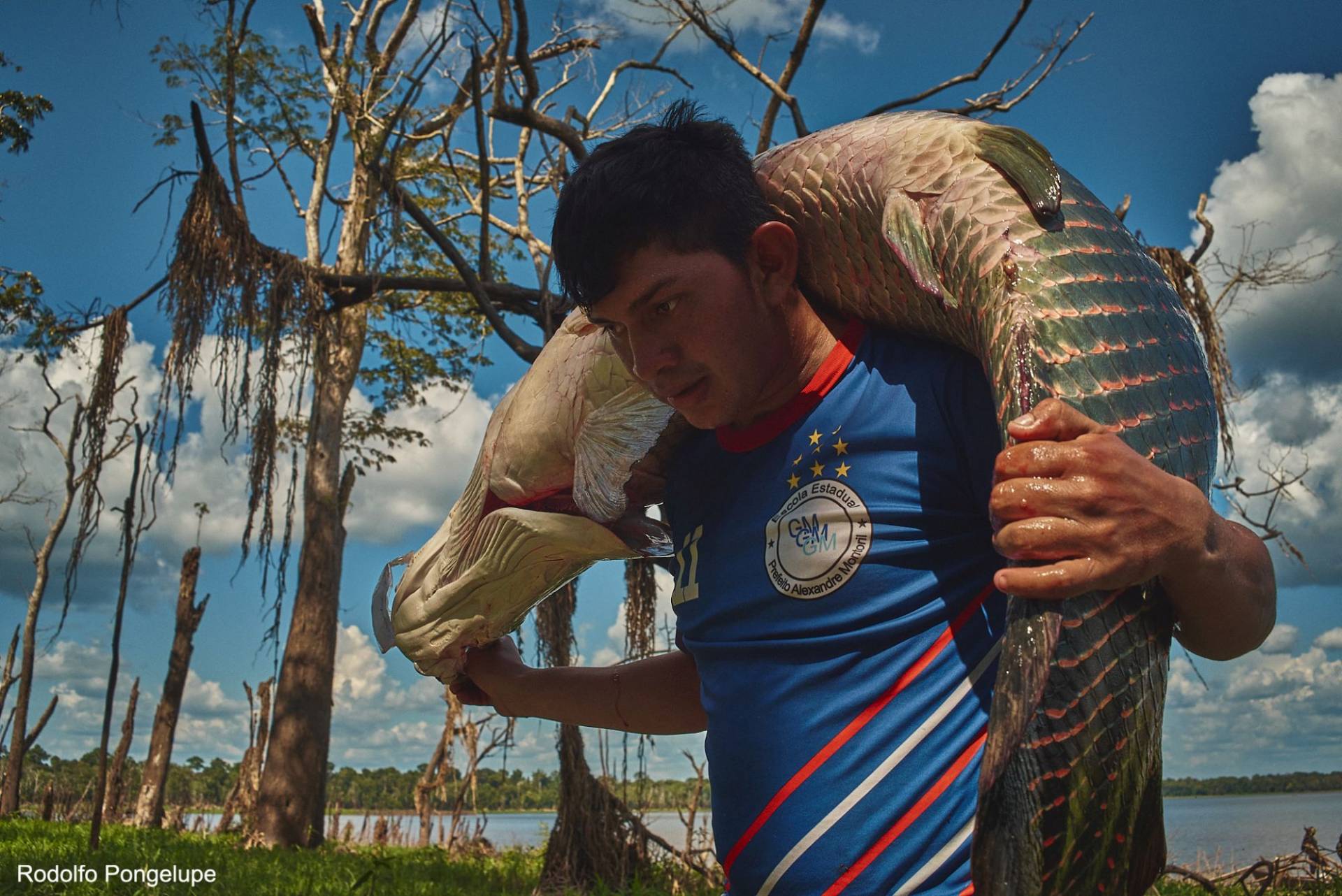 Homem carregando peixe chamado 