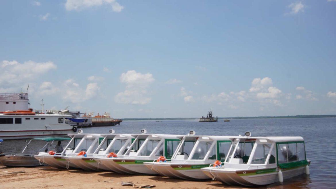 Várias 'ambulanchas' ao lado uma da outra, na beira do rio, que auxiliam no atendimento às comunidades ribeirinhas no interior do Amazonas.