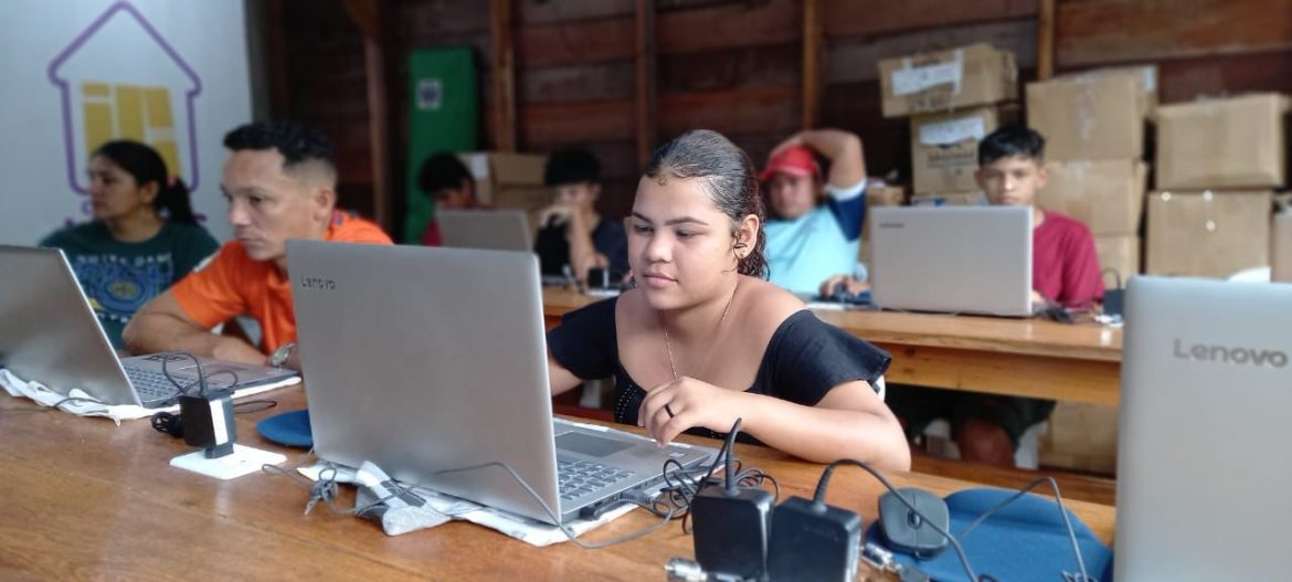Garota mexendo em notebook, durante curso de informática realizado em comunidade no interior do Amazonas.