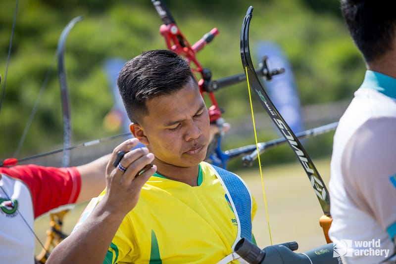 Jovem indígena praticando a modalidade de tiro com arco.