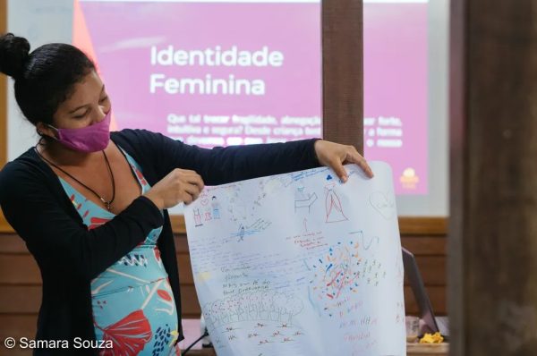 Mulher segurando cartaz que foi feito em uma atividade prática, realizada pela Fundação Amazônia Sustentável.