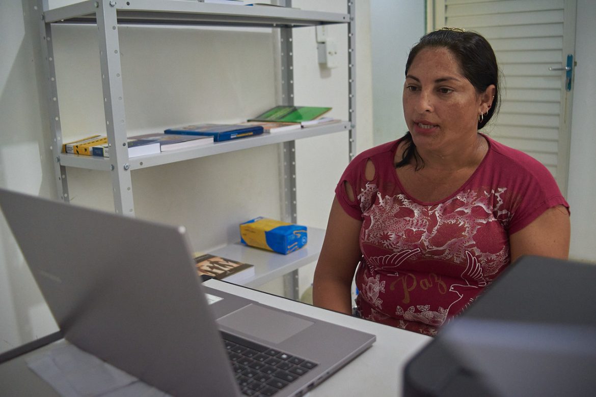 Mulher sentada recebendo atendimento via telessaúde na comunidade Boa Esperança no interior do Amazonas.