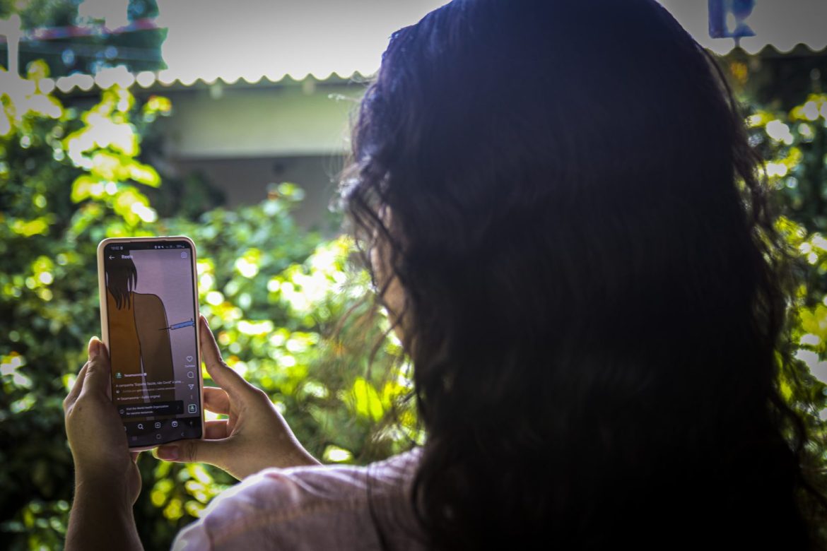 Mulher segurando o telefone e tirando foto.