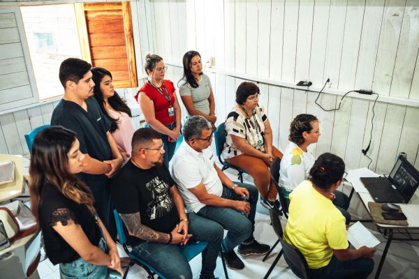 Pessoas reunidas durante videochamada com o presidente Lula para discutir sobre Telessaúde na Amazônia.